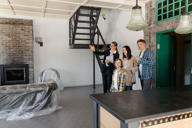 Person showing a couple and their child an unoccupied living space